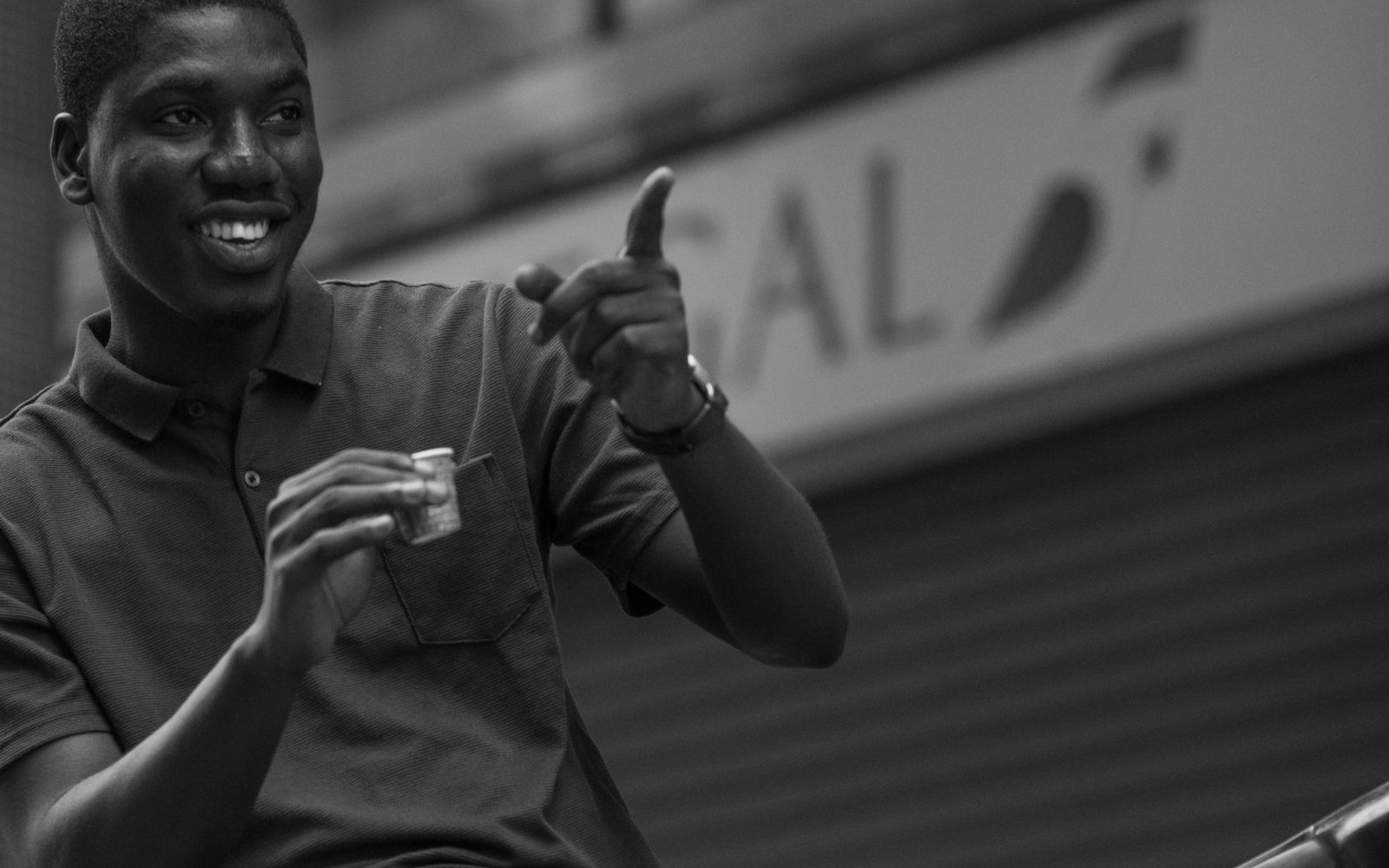 Créateur de contenus sénégalais souriant, pouce levé, dans une rue